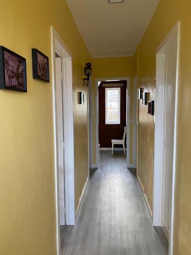 an empty hallway with yellow walls and wooden floors at CASA do CAMINHO in Praia da Vitória