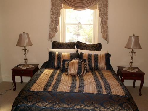 a bedroom with a bed with two lamps and a window at Archery Road Estate in Rowland Flat