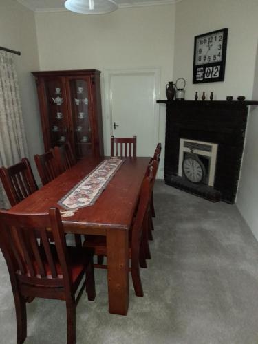 uma mesa de jantar com cadeiras e uma lareira em Archery Road Estate em Rowland Flat