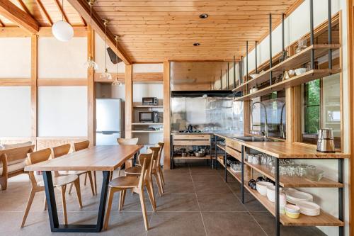 a kitchen with a wooden table and chairs at プライベートリゾート 月灯 in Atami