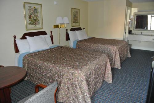 a hotel room with two beds and a table at Rodeway Inn Norcross in Norcross