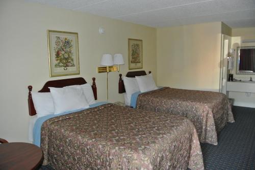 a hotel room with two beds and a table at Rodeway Inn Norcross in Norcross