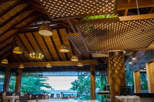 a dining room with tables and chairs and lights at Tup Kaek Sunset Beach Resort-SHA Plus in Tab Kaek Beach