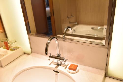 a bathroom with a sink and a bath tub at Crowne Plaza Shenzhen Futian, Near to Shenzhen Convention&Exhibition Centre, Shenzhen Stock Exchange and Shenzhen Civic Center, Outdoor Heated Pool in Shenzhen
