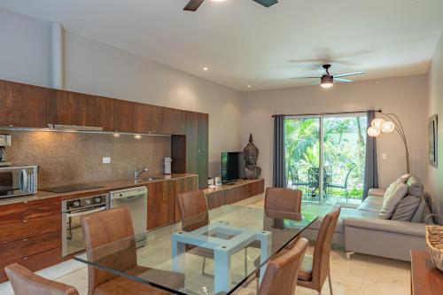 een keuken en een woonkamer met een glazen tafel bij Papaya 15 Apartments in Playa del Carmen