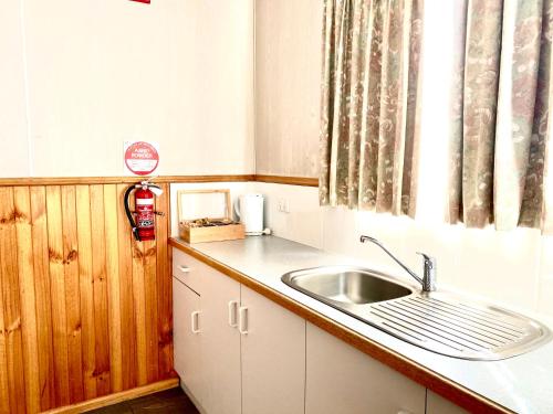 a small kitchen with a sink and a window at Holbrook Motor Village in Holbrook