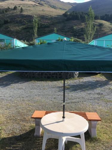 a white table with a green umbrella on top at EDEM SEVAN in Sevan