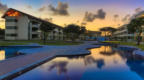 a large swimming pool in front of a building at Flat no Carneiros Beach Resort in Tamandaré