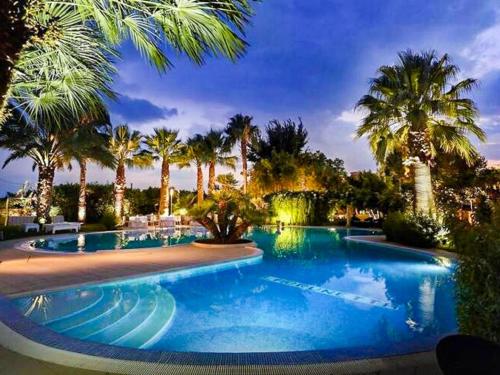 una piscina con palme in un resort di Belvilla by OYO La Brunetta a Massafra