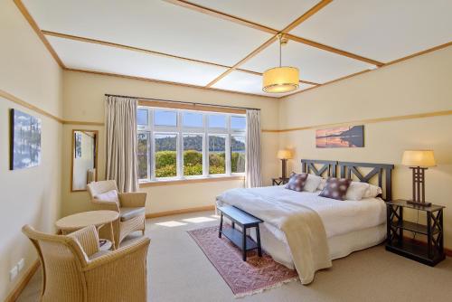 Un dormitorio con una cama grande y una ventana en Lake Brunner Eco Lodge en Moana