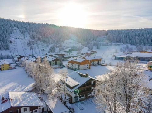 a town covered in snow with the sun in the background at Bergidyll Ramsau Top7 in Ramsau am Dachstein