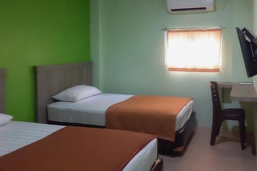 Postel nebo postele na pokoji v ubytování Guest House Anak Raja Pangkalan Bun Syariah Mitra RedDoorz