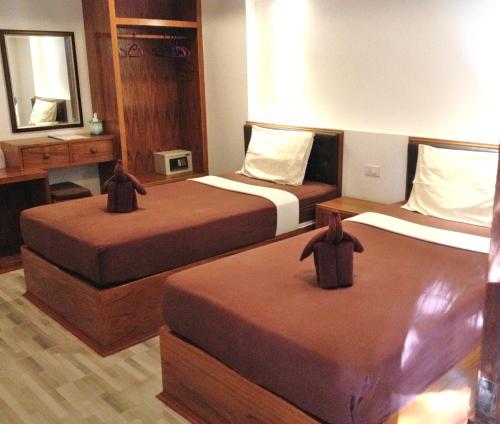 una camera d'albergo con due letti e uno specchio di Nid's Bungalows a Chaweng Beach
