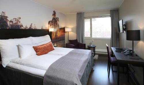 a hotel room with a bed and a desk and a desk at Grand Hotel Skei - Unike Hoteller in Skei 