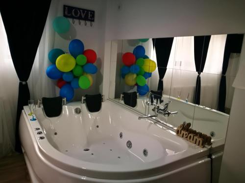 a bath tub with balloons in front of a mirror at Iași Jacuzzi Apartment F in Iaşi