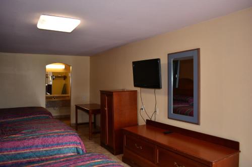 sypialnia z łóżkiem, komodą i lustrem w obiekcie El Camino Motel w mieście Beeville