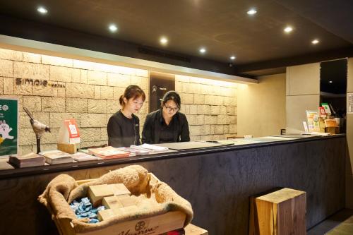 deux femmes debout à un comptoir dans un magasin dans l'établissement Simple + Hotel, à Taipei