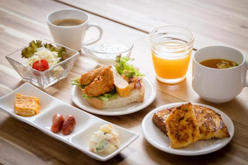 a table with plates of food and a cup of orange juice at fico HIJI in Hiji