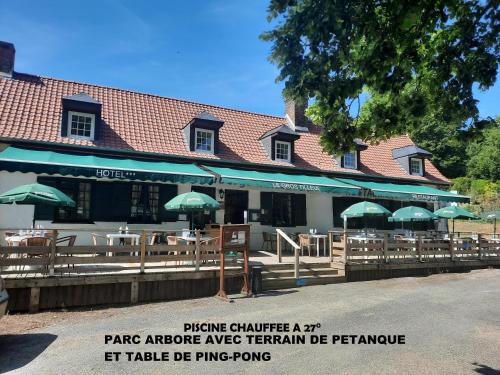 a restaurant with tables and umbrellas in front of it at Auberge du Gros Tilleul in Argoules