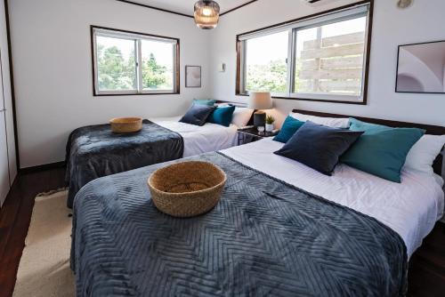 Ocean View Terrace BISE في موتوبو: غرفة نوم بسريرين ونوافذ