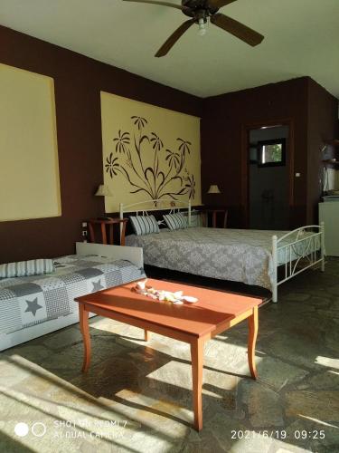 a bedroom with two beds and a coffee table at Country Art Studio Alkyoni in Kokkino Nero