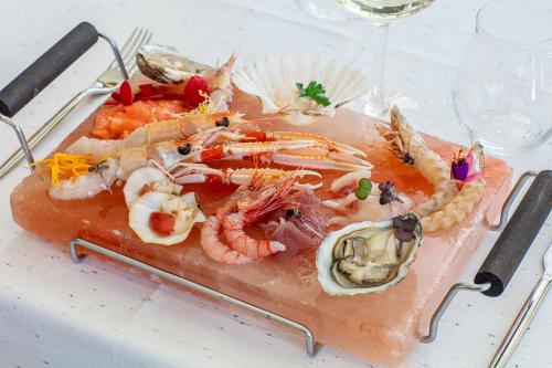 a plate of shrimp and other seafood on a table at THE ONE CAORLE - Hotel & Apartments in Caorle