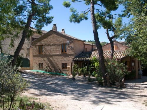 a large stone house with trees in front of it at B&B La Cappellania in Montegiorgio