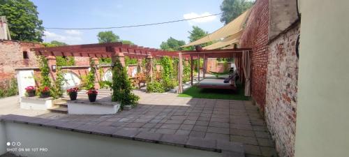 a patio with potted plants and a brick building at Noclegi Szymrych in Chełmsko Śląskie