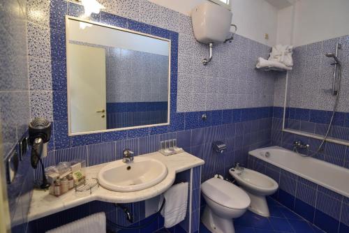 a bathroom with a sink and a toilet and a mirror at Hotel Palma in Pompei