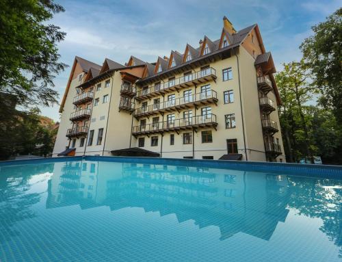a hotel with a swimming pool in front of a building at VitaPark Stariy Dub in Truskavets