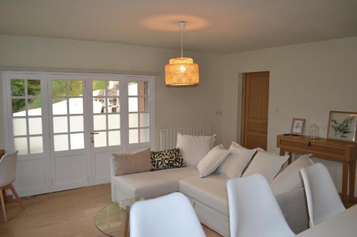 un salon avec un canapé blanc et une table en verre dans l'établissement Ambiance Seine - appartement 46m2 terrasse - Hortensia, à Thomery