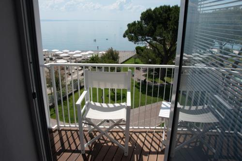 a balcony with two chairs and the ocean at Albergo alla Spiaggia in Grado