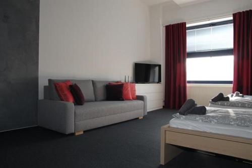 a living room with a couch and a tv and a window at Downtown Apartments in Plzeň