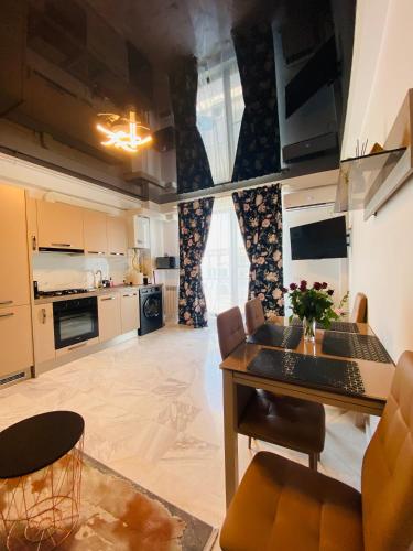 uma grande cozinha com mesa e cadeiras num quarto em Maze Apartment em Mamaia Nord – Năvodari