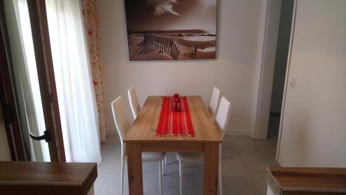 a wooden table with white chairs and a red napkin on it at Levantes in Asprovalta