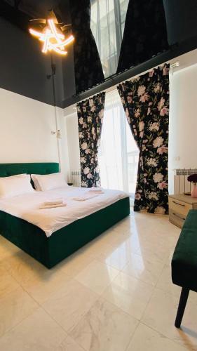 um quarto com uma cama e uma grande janela em Maze Apartment em Mamaia Nord – Năvodari