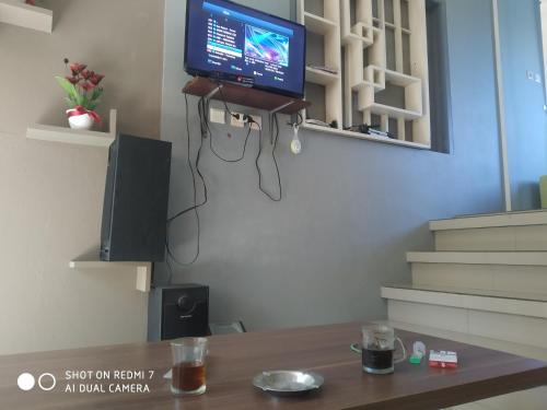 een woonkamer met een tv en een tafel bij RR Homestay seroja in Garung