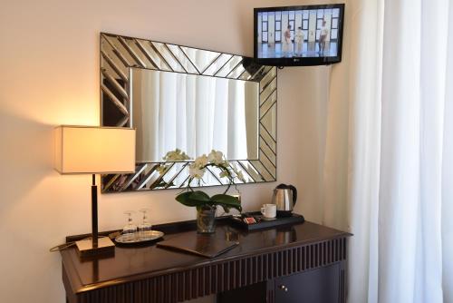 a room with a table with a lamp and a mirror at Hotel Palma in Pompei