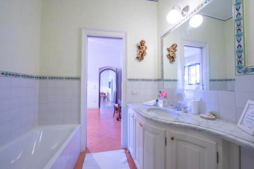 een witte badkamer met een bad en een wastafel bij Villa Faccioli Limone With Shared Pool in Colognola ai Colli