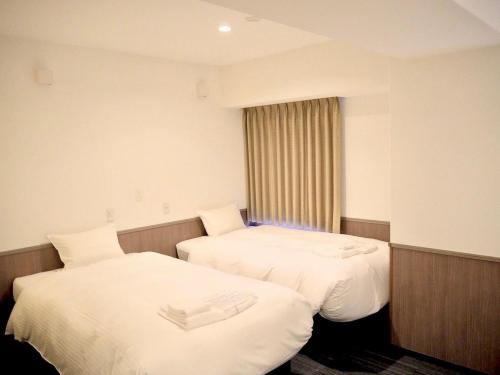 Habitación de hotel con 2 camas y ventana en Hotel Excellence Enmachi Ekimae, en Kioto