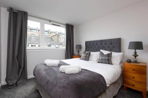 um quarto com uma cama grande e uma janela em The Edinburgh Rooftop Terrace em Edimburgo