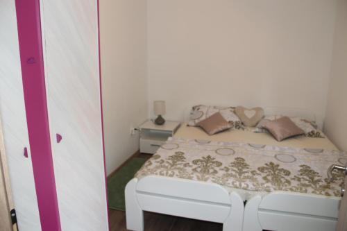 ein Schlafzimmer mit einem weißen Bett mit Kissen in der Unterkunft Apartman ANA Livno - biker friendly in Livno