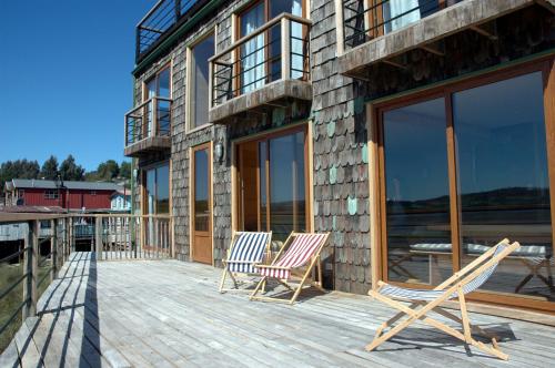 two chairs on the deck of a house at Palafito 1326 Hotel Boutique Chiloé in Castro