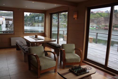 a room with a table and chairs and a large window at Palafito 1326 Hotel Boutique Chiloé in Castro