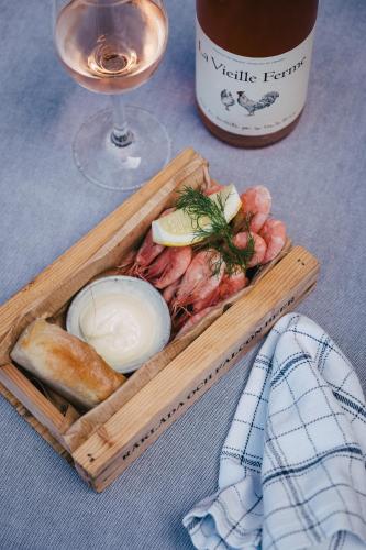 a wooden tray of food and a glass of wine at Björholmen Hotell & Restaurang in Björholmen