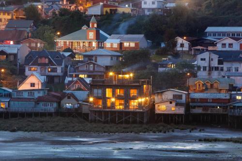 a city at night with houses and lights at Palafito 1326 Hotel Boutique Chiloé in Castro