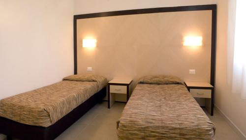 ein Hotelzimmer mit 2 Betten und 2 Tischen in der Unterkunft Junior Depandance in Cavallino-Treporti