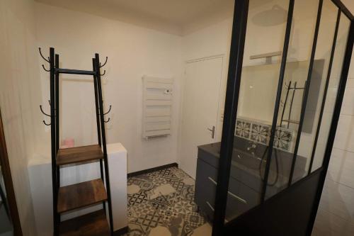 łazienka z czarną komodą i lustrem w obiekcie Gîtes du Franc Rosier w mieście Rigny-Ussé