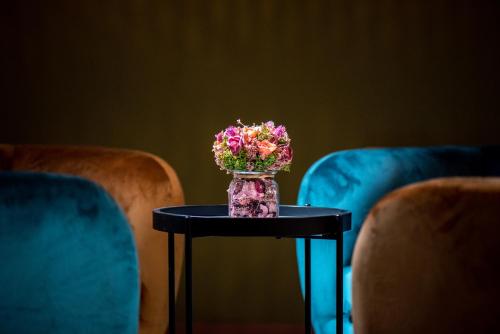 a vase filled with flowers sitting on a table at Park Hotel Kaylaka in Pleven