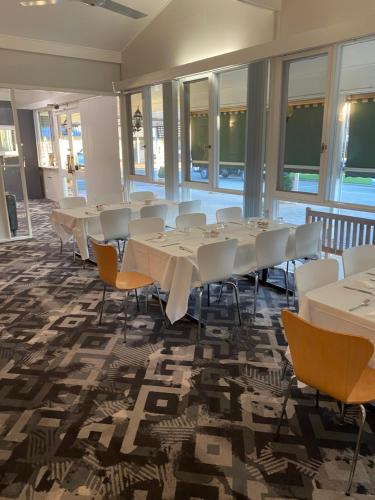 a conference room with tables and chairs and windows at City Park Motel and Apartments in Wagga Wagga